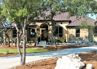 Bulverde Custom Homes - rock and stucco home with brown metal roof
