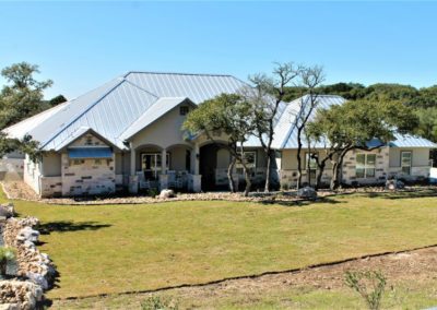 Garden Ridge custom homes rock and stucco home with standing seam metal roof in Ramble Ridge subdivision in Garden Ridge Texas