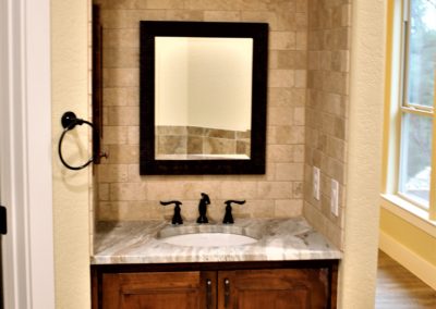 Master bath vanity alcove with arched tile ceiling marble counter top and bronze faucet