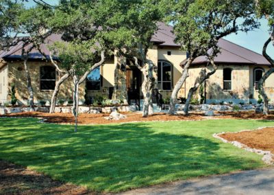 Rock and stucco home with dark brown standing seam metal roof