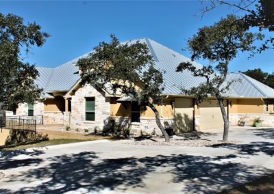 Rock and stucco home exterior with silver standing seam metal roof