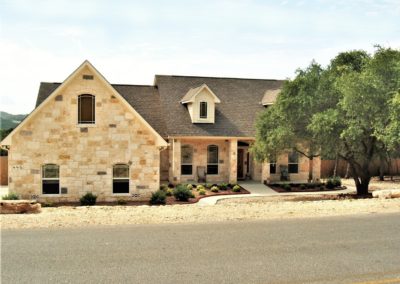 Country style rock home with shingle roof at Canyon Lake Texas