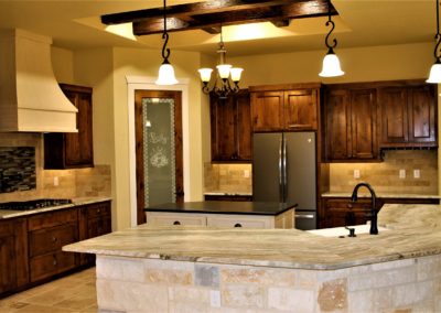 Custom Alder Kitchen Cabinets. Dark brown alder kitchen cabinets with white antiqued vent hood and white antiqued island cabinets