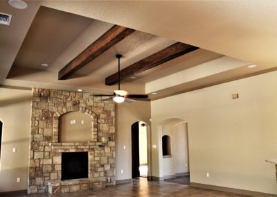 Custom Home Great Room. Spring Branch Texas custom homes. Dark rock stone fireplace tile floors and wood ceiling beams