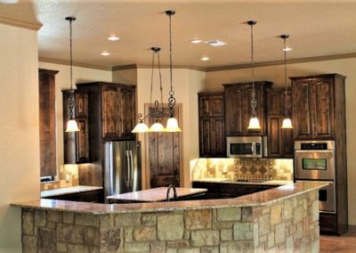 Dark Alder Custom Cabinets with granite countertops and stainless steel appliances