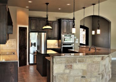 Dark Alder Kitchen Cabinets. Bulverde Texas custom home. Alder wood kitchen cabinets with granite countertops and stainless steel appliances