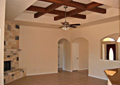 Canyon Lake Texas home Interior. Great room with faux wood ceiling beams stone fireplace and tile floors