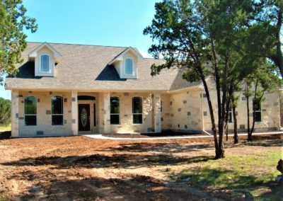 Hill Country Custom Homes. Home exterior with cream and black accent rocks in the Texas Hill Country