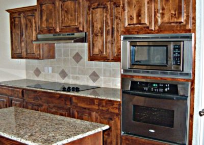 Knotty Alder Cabinets with raised panel doors and granite countertops with tile backsplash