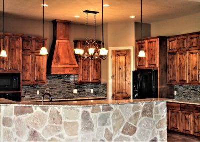Knotty Alder Custom Kitchen Cabinets with rock bar wall and glass tile backsplash