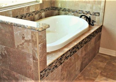 Master Bath Garden Tub. White garden tub and roman tub faucet in tiled alcove of master bathroom