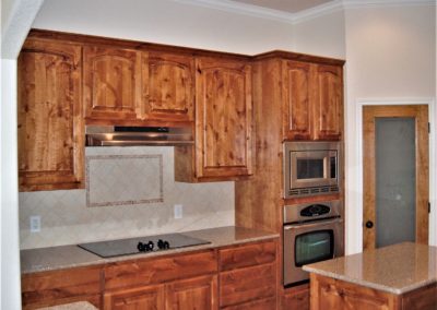 rustic alder kitchen cabinets with granite countertops and stainless steel appliances