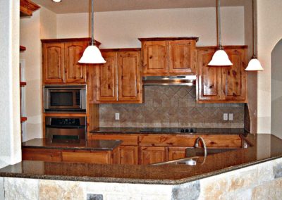 Rustic Alder Kitchen Cabinets with Baltic Brown granite countertops and tile backsplash
