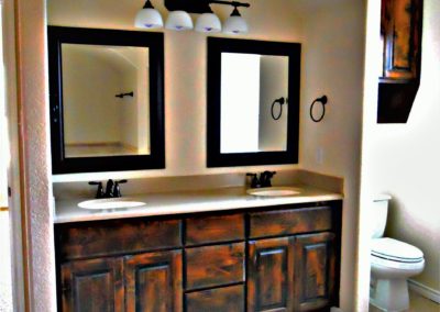 dark alder bath vanity with double sinks two mirrors and bronze light fixture