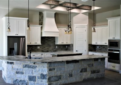 White Custom Wood Cabinets with gray rock bar wall and granite counter tops