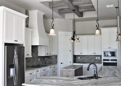 White Kitchen Cabinets. Canyon Lake Texas custom home kitchen with gray granite countertops and gray tile backsplash