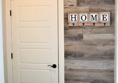 wood accent wall and white bench in mudroom