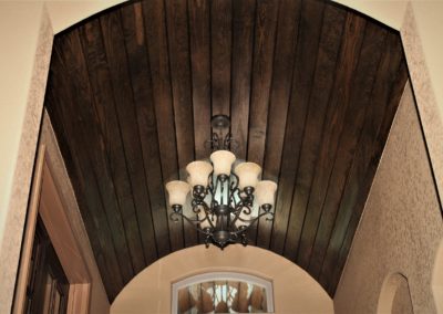 Wood Barrel Ceiling in custom home foyer. Dark wood stain and chandelier