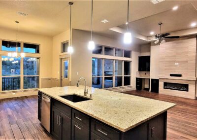 Family Room in Custom Home. Huge kitchen island with granite countertop overlooking the great room in an open floorplan