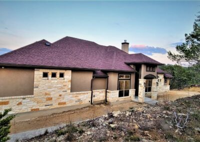 Rock and Stucco Custom Home with brown shingle roof.