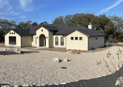 white stucco home with black shingle roof and dark bronze windows