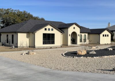 white stucco home with black roof and dark bronze windows