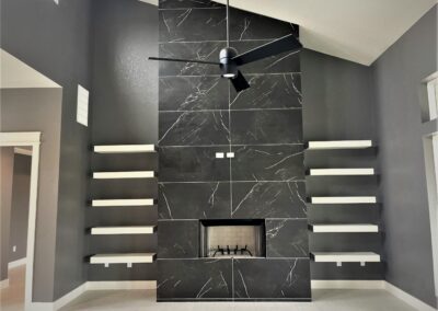 floor to ceiling tiled fireplace hearth with floating shelves on sides in modern designed home