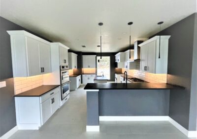 Modern kitchen with white custom cabinets and black countertops