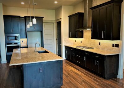 Large Kitchen Island with granite countertop and dark brown custom cabinets