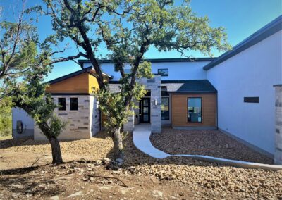 modern home exterior with grey stucco, cedar siding and multi colored stone